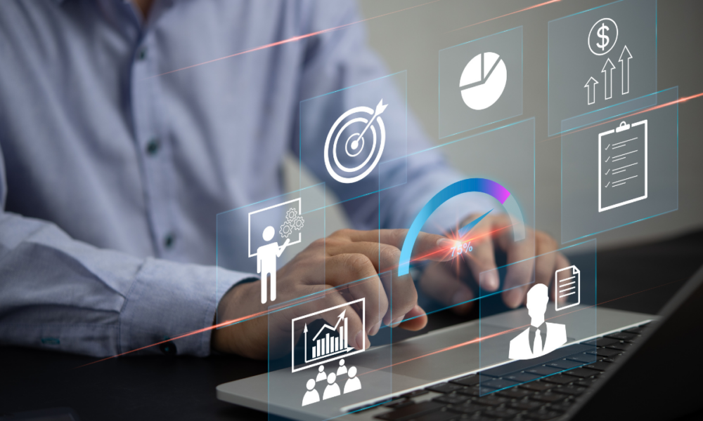 Immagine di un uomo davanti al laptop da cui escono varie icone di business intelligence.