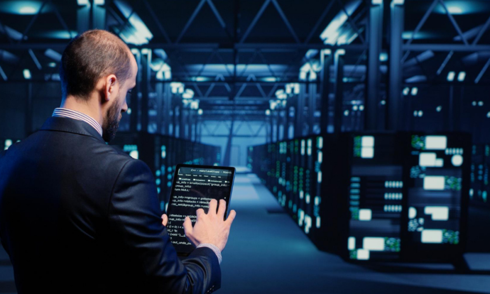Foto di un uomo di spalle mentre monitora la sicurezza delle macchine in fronte a lui.